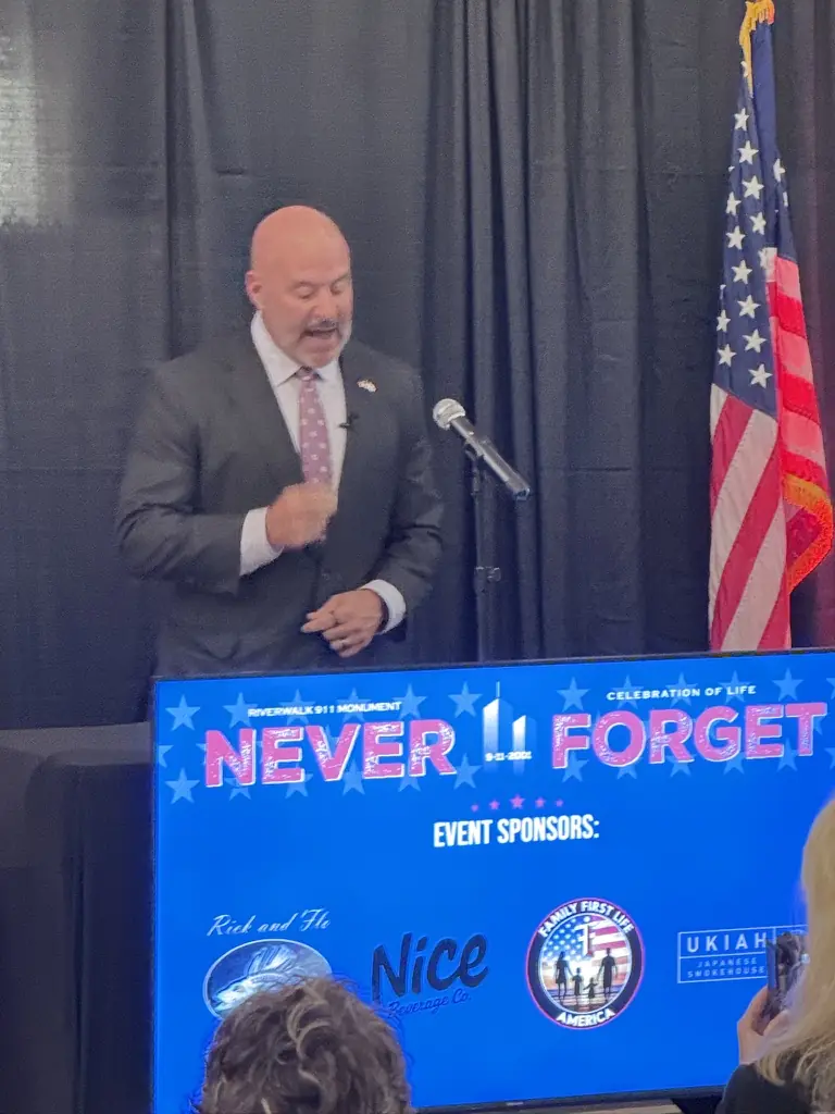A speaker at the podium beside the American flag.